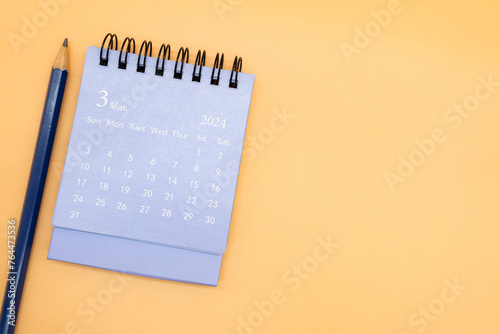 2024 March Calendar and pencil isolated on orange background. planning for business or travel concept. Copy space for text.