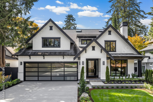 An extremely beautiful and perfectly symmetrical front view of an all white craftsman style home with a long driveway
