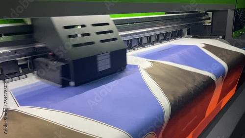 Industrial sublimation printer for digital printing on fabrics. Textile printing is the process of applying colour to fabric in definite patterns or designs photo