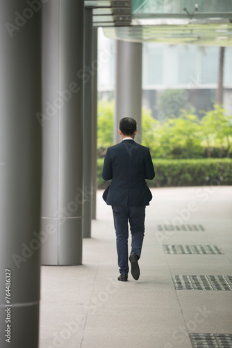 Back view of an Asian businessman walking.