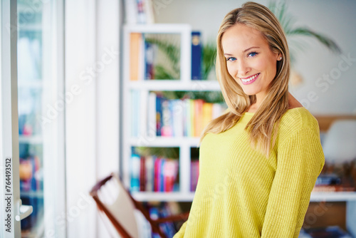 Portrait, smile and woman in a home library for weekend reading, relax or stress relief in house. Book shelf, face and female person in study room for me time, novel or chilling on weekend or day off