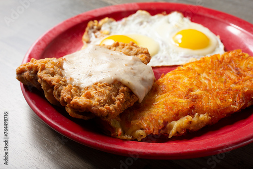 A closeup view of a country fried steak breakfast plate.