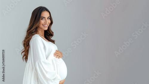 Arab pregnant woman with pregnancy belly, in soft white clothes © pariketan