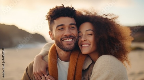 A young interracial couple in love, having fun and embracing on an autumn day at the beach, colors of diversity and love,copy space