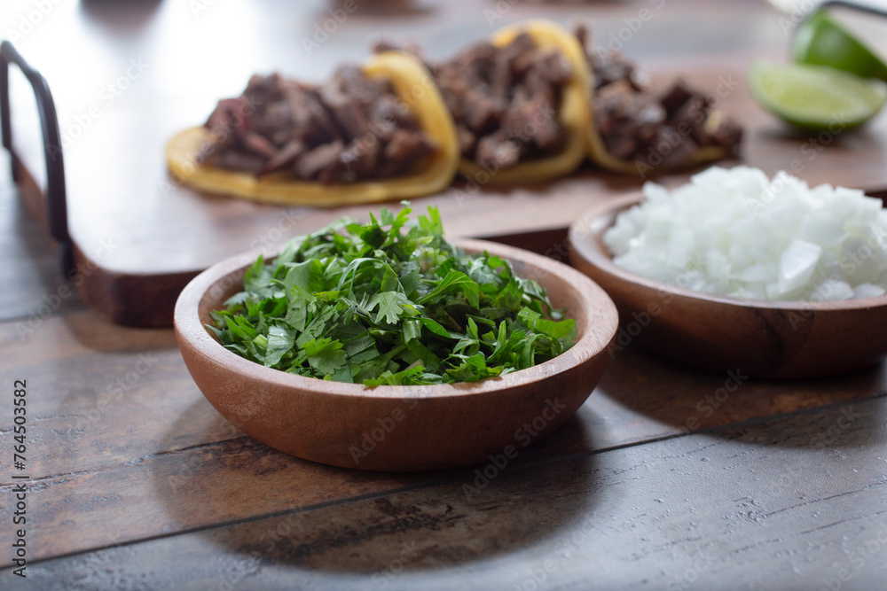 A view condiment cups of chopped cilantro and onion.