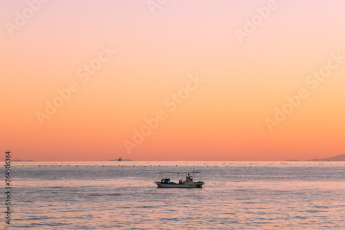 夕暮れ時の海に浮かぶ船 © Rika