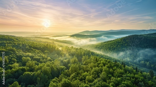 The top view picture of the wild nature that fills with green forrest  great mountain  cloudscape  blue sky  and the sun in the bright morning day in the summer or spring time of the years. AIGX01.