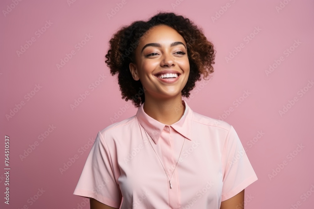 Portrait of a smiling young african american woman on pink background
