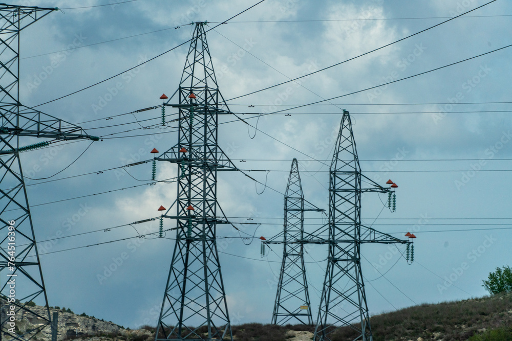 High voltage towers with sky background. Power line support with wires for electricity transmission. High voltage grid tower with wire cable at distribution station. Energy industry, energy saving