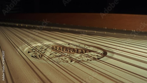 grand piano strings, slight camera movement to the right, closeup, dark, yellow wood photo