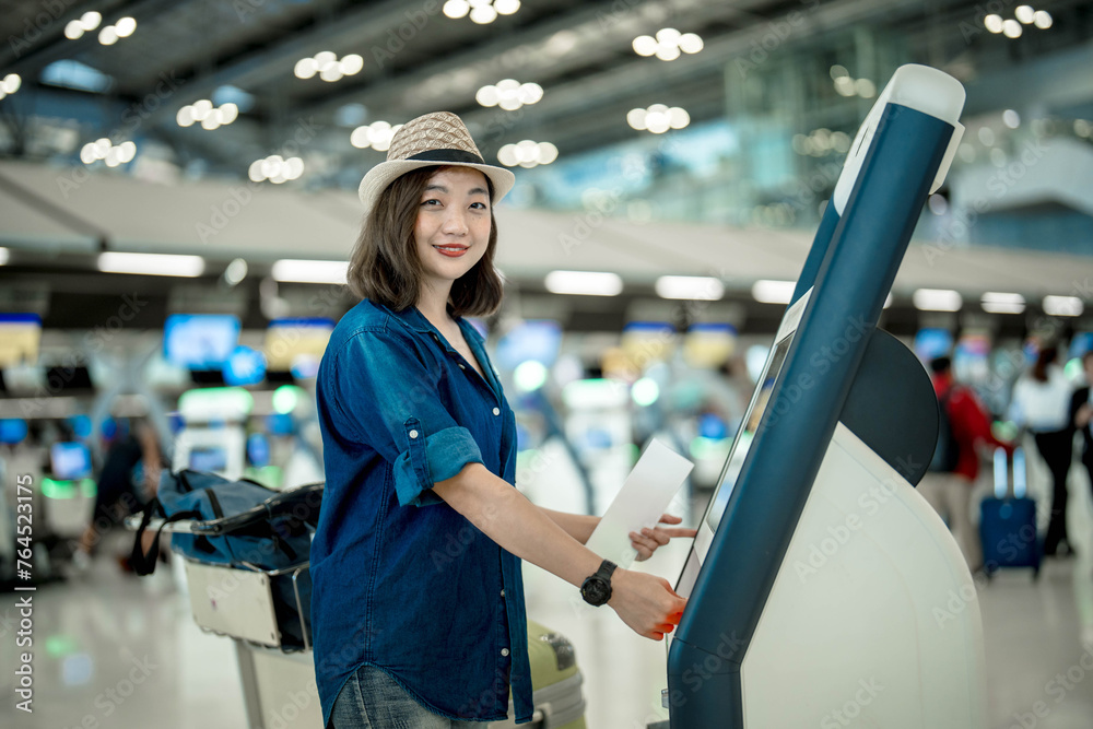 Portrait of Asian young girl using self check in machine in international airport. Portrait of Asian young girl using self check in machine in international airport.