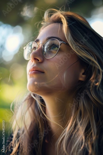 Woman with glasses looking up at the sky, perfect for technology or curiosity concepts