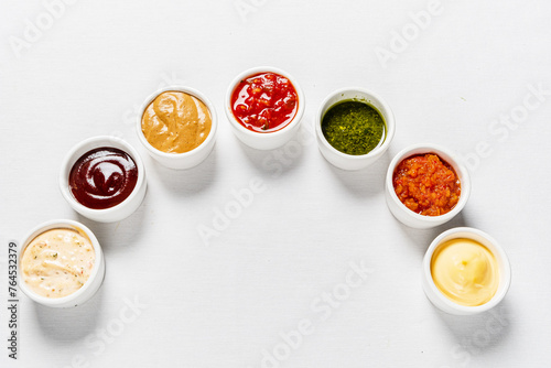 different kinds of sauces on white background