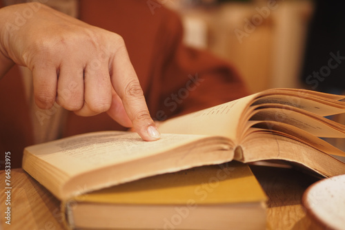 women hand holding a book at library 