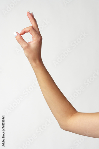 Female hand showing OK sign on white background