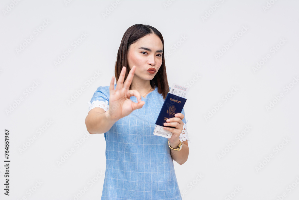 Asian woman with passport and boarding pass making OK sign, ready for travel Asian woman with passport and boarding pass making OK sign, ready for travel