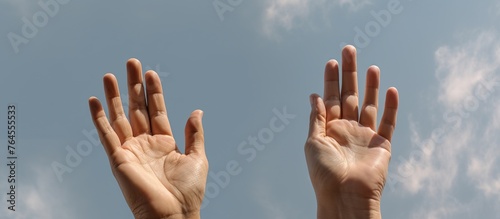a pair of hands facing the sky to pray for God's blessing with the faith and power they have in God against the background of a clear sky