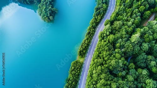 From an aerial perspective, a scenic road winds through lush green woods