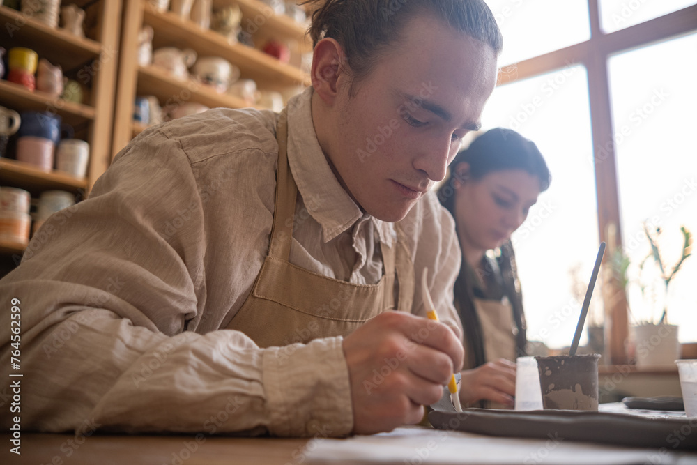 A craftman looks at the product he made in pottery workshop A craftman looks at the product he made in pottery workshop