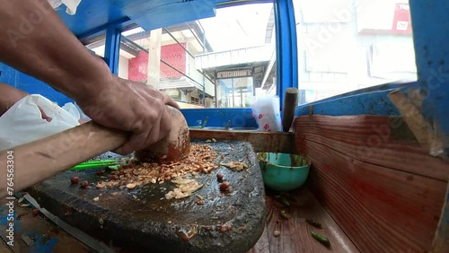 Crush peanut and stir it to make peanut butter sauce for bumbu rujak buah, indonesian street food. A footage of peanut sauce is being made in traditional way. Rujak Buah Recipe. photo