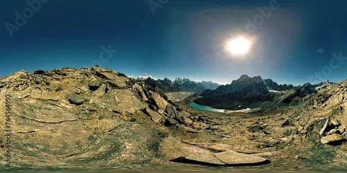 360 VR Gokyo Ri mountain top. Tibetan prayer Buddhist flag. Wild Himalayas high altitude nature and mount valley. Rocky slopes covered with snow and deep blue sky photo