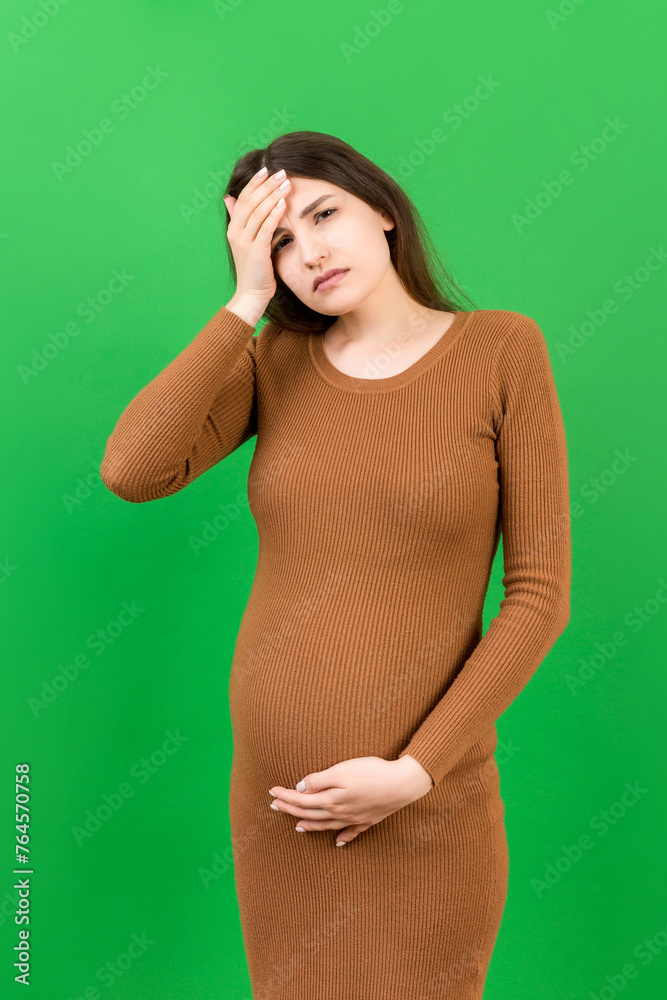 Beautiful young pregnant woman feeling head ache on colored background isolated. Stressed pregnant woman or mother problems Beautiful young pregnant woman feeling head ache on colored background isolated. Stressed pregnant woman or mother problems