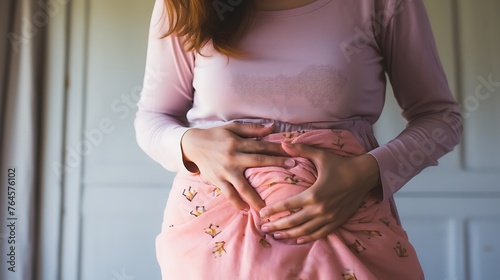 
Woman holding painkillers, suffering from menstrual pain, having cramps. Close up of woman holding abdomen, endometriosis, and conditions causing pain in tummy.