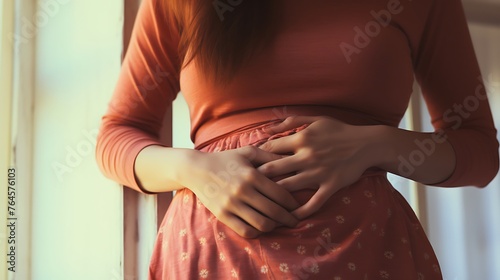 Woman holding painkillers, suffering from menstrual pain, having cramps. Close up of woman holding abdomen, endometriosis, and conditions causing pain in tummy.