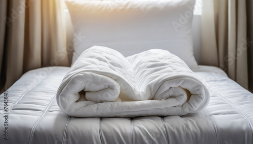 White Folded Duvet Lying on White Bed Background