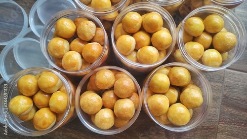 A group of small round cookies stuffed with pineapple jam from Indonesia called 'Nastar' in the jar 
