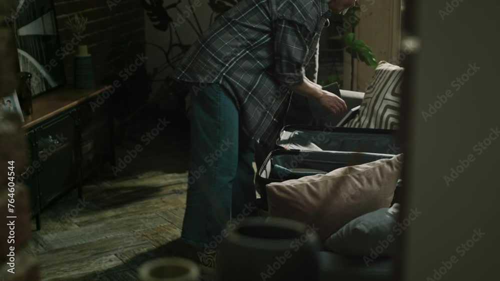 Lowkey medium shot of Caucasian adult man trying to prevent her wife to leave him and their marriage. Woman packing belongings in suitcase deciding to go away Lowkey medium shot of Caucasian adult man trying to prevent her wife to leave him and their marriage. Woman packing belongings in suitcase deciding to go away