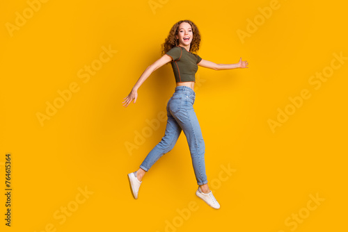 Photo of optimistic carefree cheerful girl have fun running traveling isolated on yellow color background