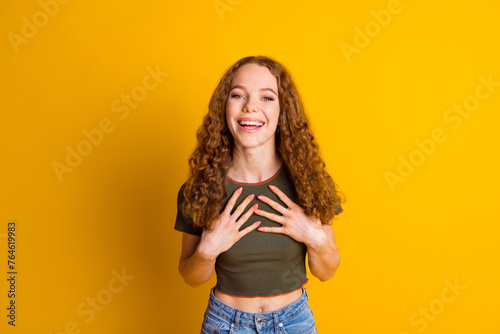 Photo of glad positive lovely good mood girl wear trendy clothes two arms touch chest isolated on vivid yellow color background