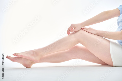 Fototapeta Naklejka Na Ścianę i Meble -  Isolated on the legs, hands and white background of a young Asian woman on a diet.