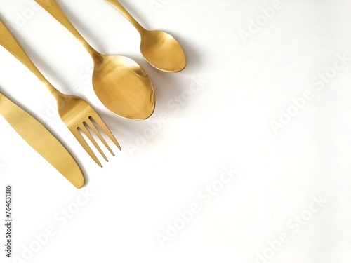 Gold cutlery, knife, fork, spoon isolated on a white background with copy space 