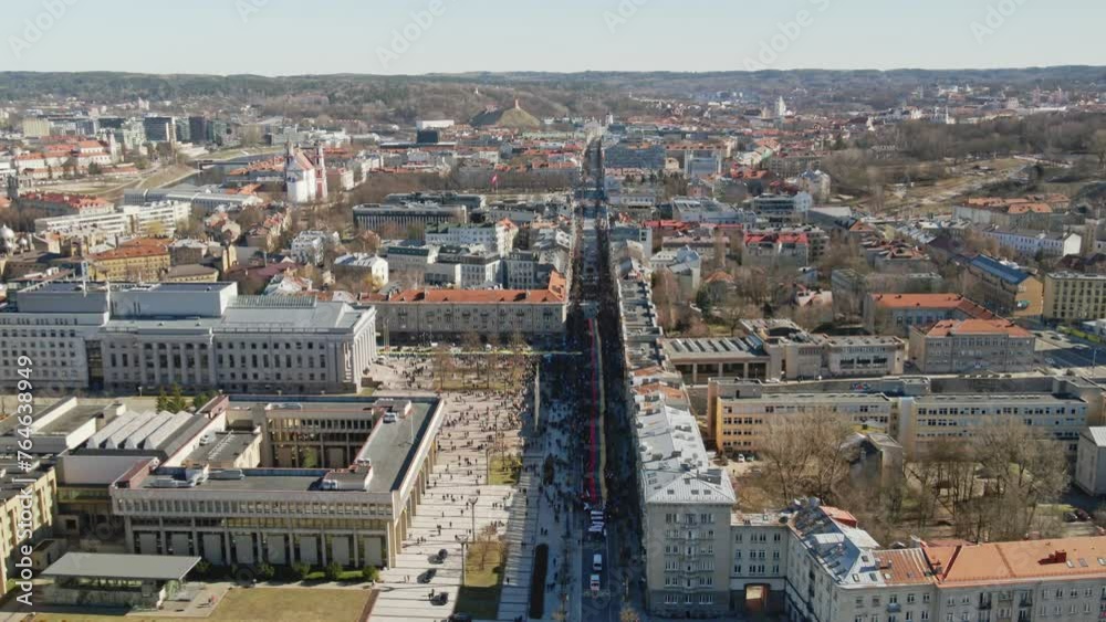 Vilnius city centre during Independence Day celebration, aerial view of a parade with a long national flag of Lithuania Vilnius city centre during Independence Day celebration, aerial view of a parade with a long national flag of Lithuania