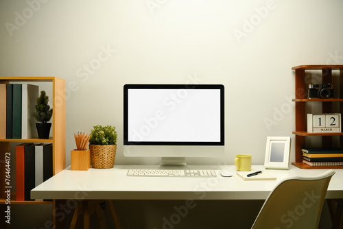 White blank screen computer monitor, houseplant and coffee cup on working table © Prathankarnpap