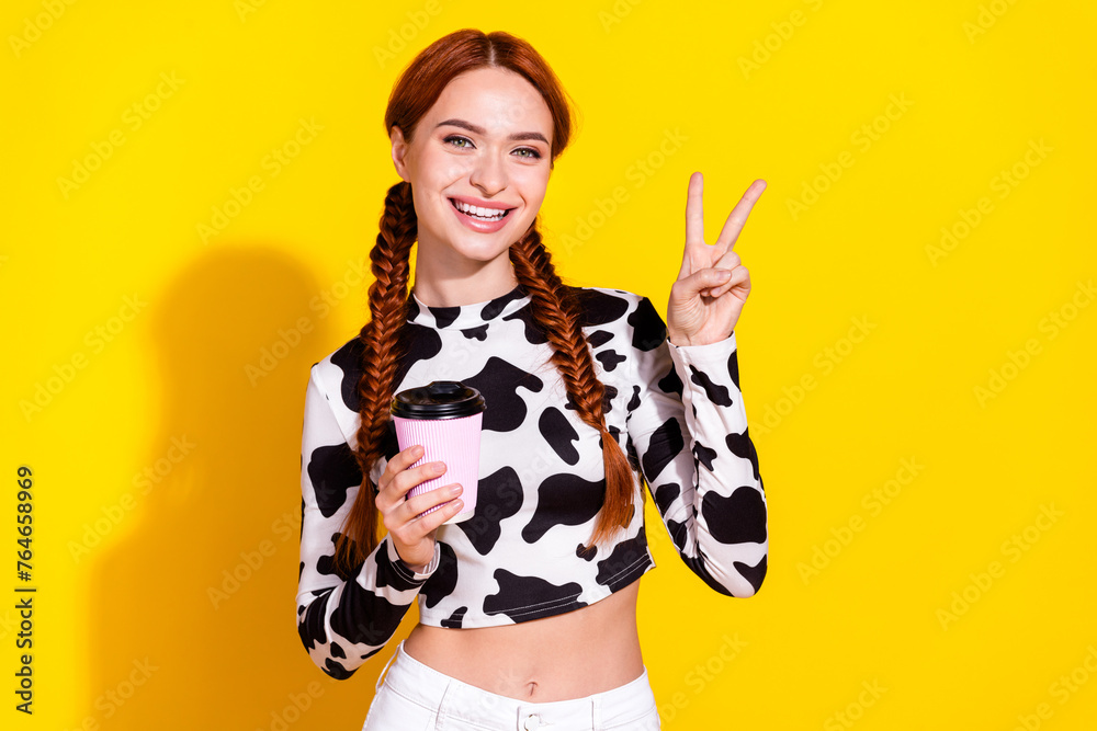 Photo of good mood funky lady dressed cowskin print top showing v-sign enjoying tea isolated yellow color background - obrazy, fototapety, plakaty 