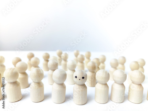 Wooden figurines with a leader and a group with partial focus. The concept of distinguishing a leader from the crowd. Sighted, intelligent, different among the blind group
