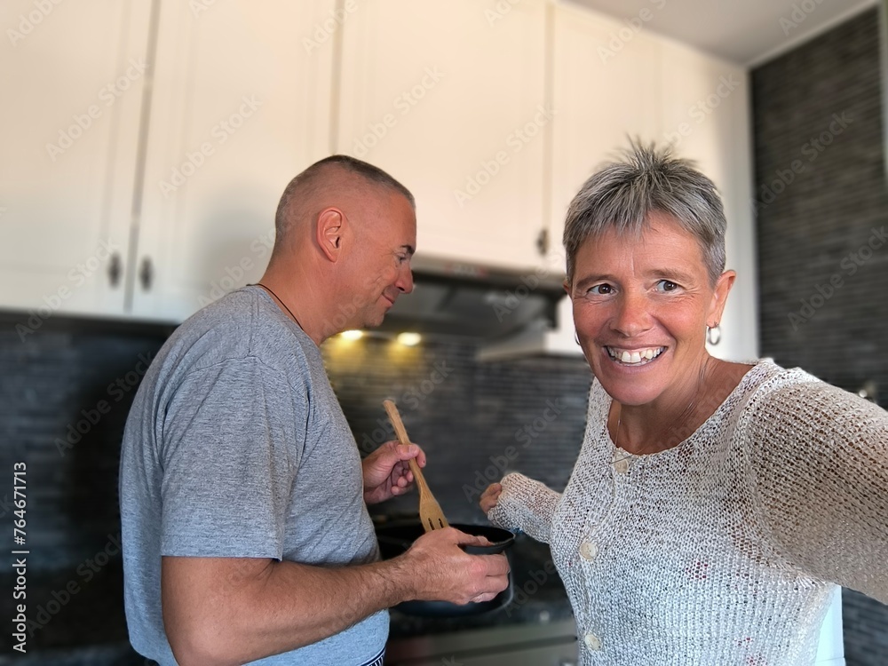 Happy couple cooking together. Husband and wife in their kitchen at home preparing healthy food.Couple in love preparing meal together in the kitchen.The couple's affinity is measured in the kitchen. Happy couple cooking together. Husband and wife in their kitchen at home preparing healthy food.Couple in love preparing meal together in the kitchen.The couple's affinity is measured in the kitchen.