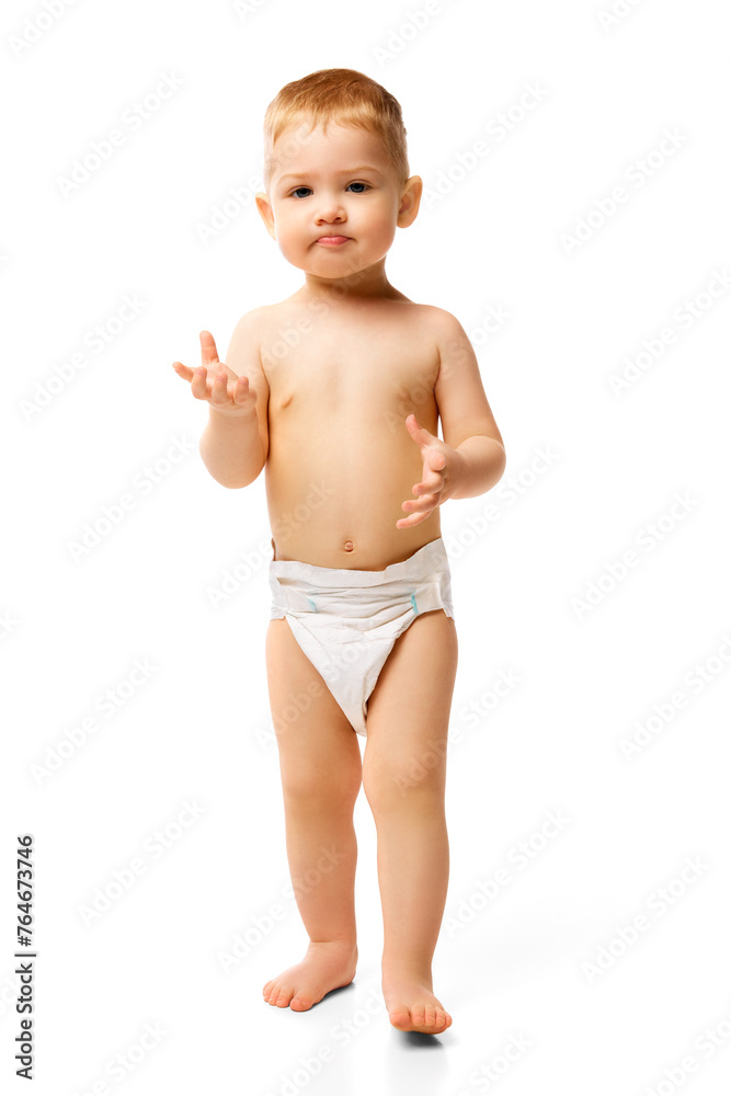 Full-length image of little baby boy, child standing in diaper isolated over white studio background. Concept of childhood and family, care, parenthood, infancy and heath Full-length image of little baby boy, child standing in diaper isolated over white studio background. Concept of childhood and family, care, parenthood, infancy and heath