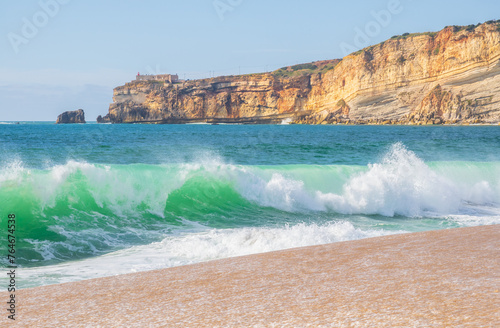 Wave and cliffs in Atlantic Ocean on the beach in Nazaré, Portugal