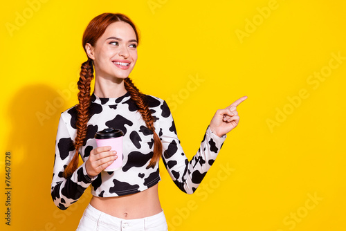 Photo of sweet dreamy lady dressed cowskin print top enjoying milk showing finger empty space isolated yellow color background
