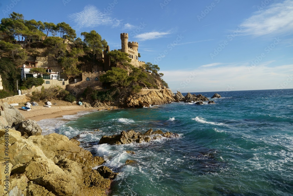 Spain. Coast of the Costa Brava. Catalonia. Lloret de Mar. Mediterranean Sea. Beautiful rocks. A sea wave hits the shore. Foam and sea spray