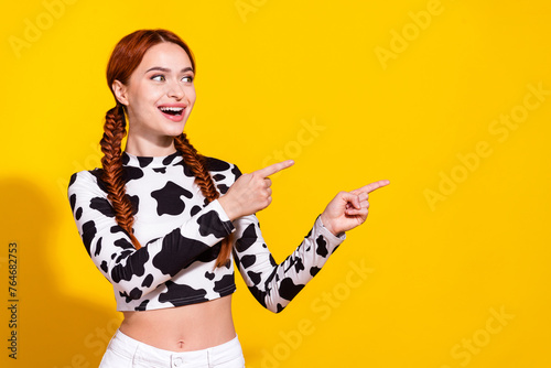 Photo of excited funky lady dressed cowskin top showing two fingers looking empty space isolated yellow color background