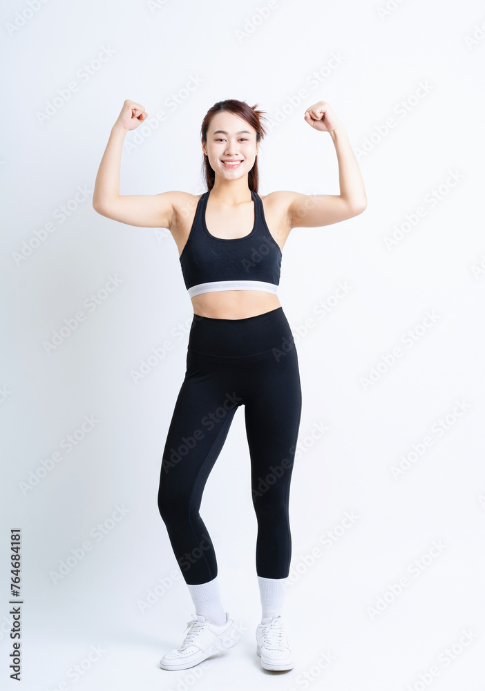 Young Asian woman wearing sportswear on white background