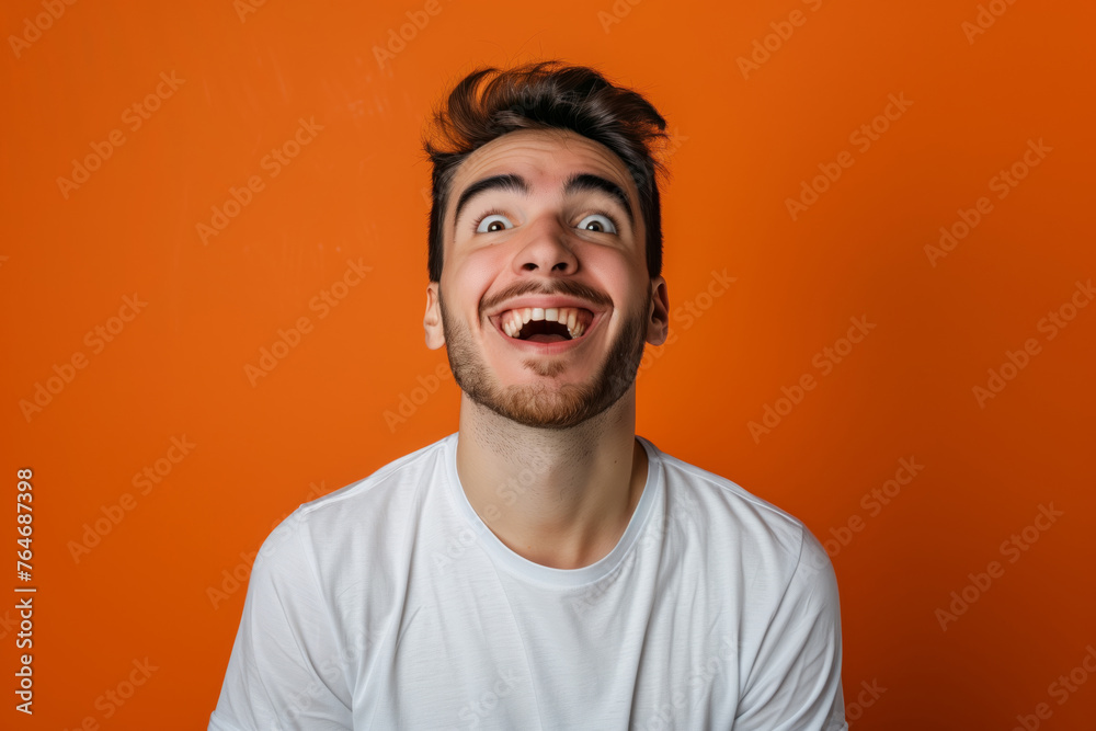 A man makes funny, sad, horrible grimaces, makes a face on a coloured background A man makes funny, sad, horrible grimaces, makes a face on a coloured background