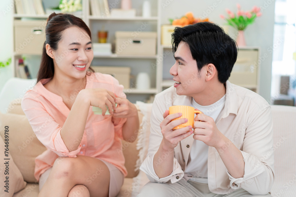 Photo of young Asian couple at home