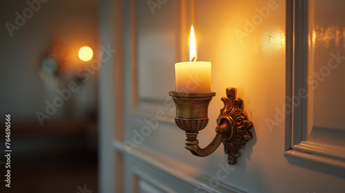A candle is lit in a gold candlestick holder