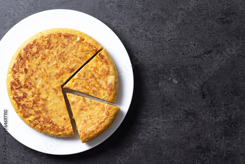 Traditional spanish omelette on black background. Top view. Copy space